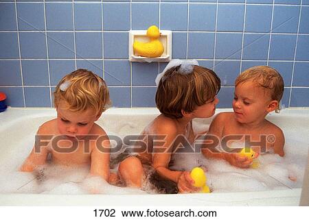 Stock Image - Three brothers take bubble bath. Fotosearch