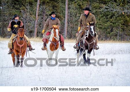 Picture - Three cowboys riding horses. Fotosearch