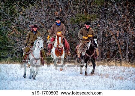 Stock Image - Three cowboys riding horses. Fotosearch