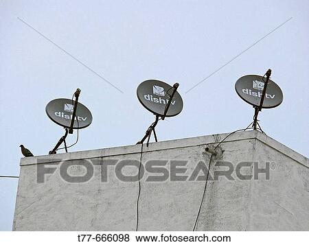 Three dish antennas of a television set are in a row on a building terrace. Pune, Maharashtra, India. View Large Photo Image Stock Photo - Three dish antennas of a television set are in a row on a building terrace. Pune, Maharashtra, India.. Fotosearch