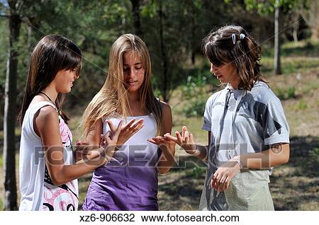 Stock Image - three friends at the park counting on his fingers. Fotosearch