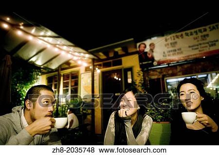 Three friends enjoying coffee and laughter at an outdoor cafe in Los Angeles, California View Large Photo Image Stock Photo - Three friends enjoying coffee and laughter at an outdoor cafe in Los Angeles, California. Fotosearch