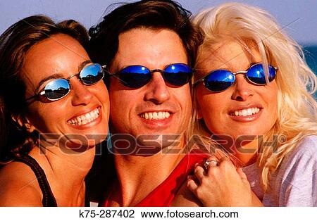 Stock Image - three friends wearing sunglasses. Fotosearch