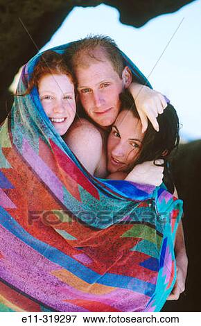 Three friends wrapped in a beach towel View Large Photo Image Stock Photo - Three friends wrapped in a beach towel. Fotosearch