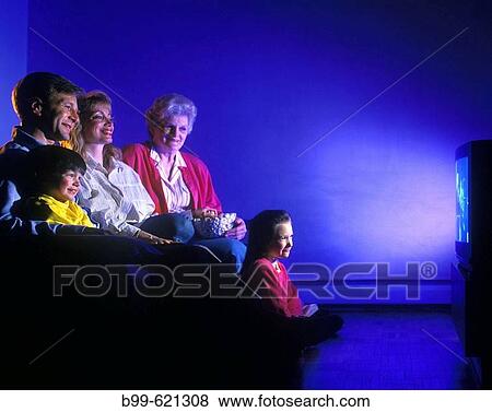 Stock Photo - three generation family sitting on couch watching television. Fotosearch
