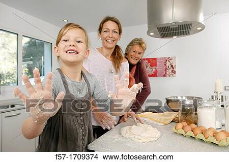 Picture - Three generations of women in the kitchen. Fotosearch