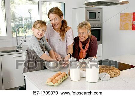 Stock Image - Three generations of women in the kitchen. Fotosearch