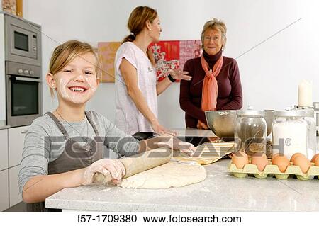 Stock Image - Three generations of women in the kitchen. Fotosearch