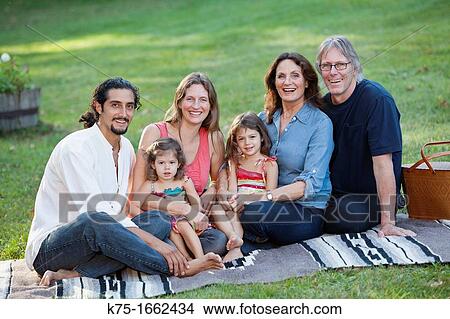 Three generations sitting on blanket on lawn View Large Photo Image Picture - Three generations sitting on blanket on lawn. Fotosearch
