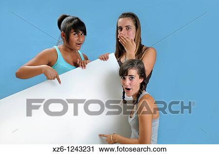 Stock Image - Three girls holding a blank sign, with blue backgroud. Fotosearch