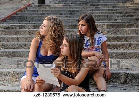 Three girls looking at a plane sitting on stairs, Girona, Catalonia, Spain, Europe View Large Photo Image Stock Photography - Three girls looking at a plane sitting on stairs, Girona, Catalonia, Spain, Europe. Fotosearch