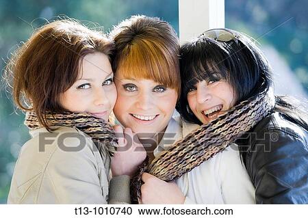 Three happy girlfriends close together with just one scarf View Large Photo Image Stock Image - Three happy girlfriends close together with just one scarf. Fotosearch