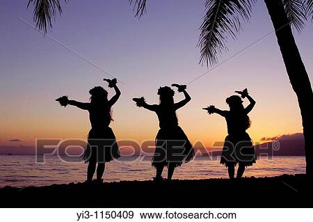 Stock Photo - Three hula dancers perform at sunset framed by a palm tree at Olowalu, Maui, Hawaii, USA. Fotosearch