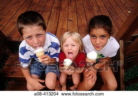 Three kids eat vanilla ice cream cones. USA. View Large Photo Image Picture - Three kids eat vanilla ice cream cones. USA.. Fotosearch
