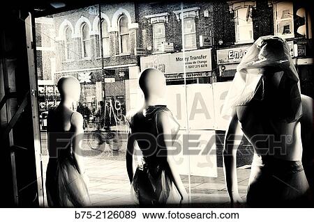 Stock Photo - Three mannequins in a shop window seen from the inside to the street. London, England, UK. Fotosearch