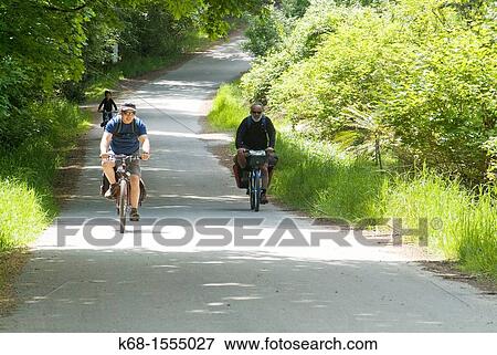 three people bicycling on a country road on Saltspring Island, BC, Canada View Large Photo Image Stock Photo - three people bicycling on a country road on Saltspring Island, BC, Canada. Fotosearch