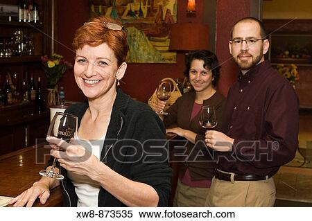 Stock Photography - Three people enjoying wine tasting. Fotosearch