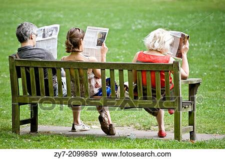 Three people on a garden bench read newspapers, taken in London on April 2011. View Large Photo Image Stock Photo - Three people on a garden bench read newspapers, taken in London on April 2011.. Fotosearch