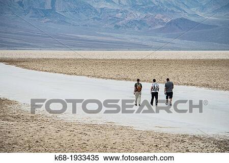 Three people walk in the desert at Badwater, Death Valley National Park, California, USA View Large Photo Image Stock Photography - Three people walk in the desert at Badwater, Death Valley National Park, California, USA. Fotosearch