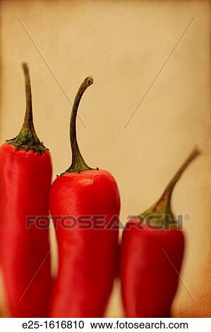 Stock Image - Three red chillis close up with a textured finish.. Fotosearch