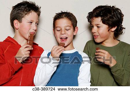 Picture - three sharing chocolate. Fotosearch