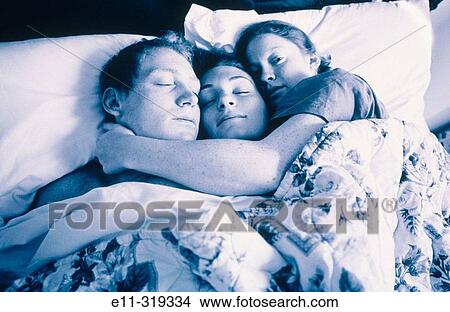 Picture - Three siblings snuggle in bed. Fotosearch