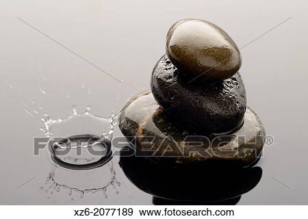 Three Spa stones on water and a close up of a water droplet splashing. View Large Photo Image Stock Photo - Three Spa stones on water and a close up of a water droplet splashing.. Fotosearch