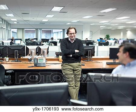 Stock Image - Three traders having a discussion in an office. Fotosearch