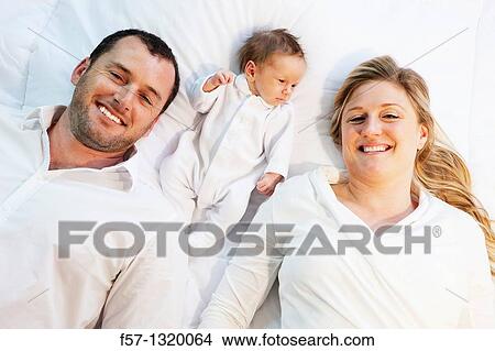 Three week old baby boy with parents. View Large Photo Image Picture - Three week old baby boy with parents.. Fotosearch