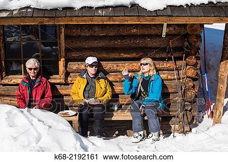 Three women skiers sit by a log cabin in winter at the Elizabeth Parker hut, Lake O? Hara, Yoho National Park, British Columbia, Canada. View Large Photo Image Stock Image - Three women skiers sit by a log cabin in winter at the Elizabeth Parker hut, Lake O? Hara, Yoho National Park, British Columbia, Canada.. Fotosearch