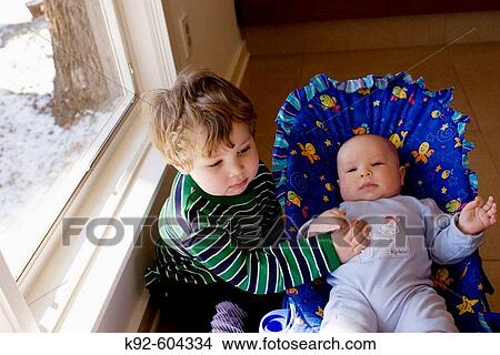 Three year old boy and his four month old baby brother. View Large Photo Image Picture - Three year old boy and his four month old baby brother.. Fotosearch