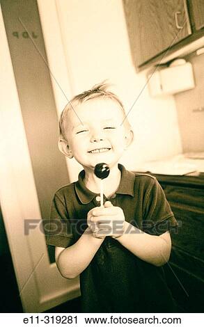 Three year old boy holds tootsie pop (sepia tone) View Large Photo Image Stock Image - Three year old boy holds tootsie pop (sepia tone). Fotosearch