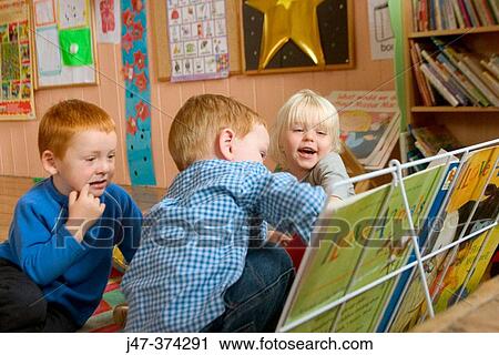 Stock Image - Three year old children reading together at nursrey school. Fotosearch