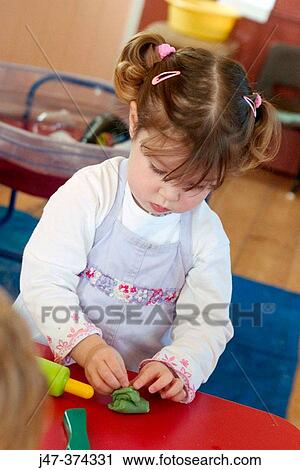 Three year old girl, playing with playdoe at nursrey school View Large Photo Image Stock Image - Three year old girl, playing with playdoe at nursrey school. Fotosearch