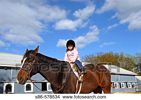 Three year old girl riding a horse, Stanhope Stables, Huntington, NY. View Large Photo Image Picture - Three year old girl riding a horse, Stanhope Stables, Huntington, NY.. Fotosearch