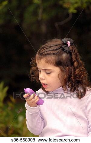 three year old girl, tranquil outdoor setting, speaking into toy telephone View Large Photo Image Stock Photo - three year old girl, tranquil outdoor setting, speaking into toy telephone. Fotosearch