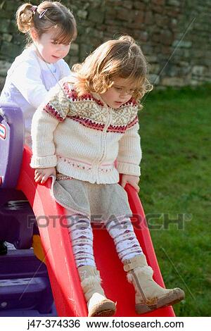 Three year old girls playing on a slide View Large Photo Image Stock Photograph - Three year old girls playing on a slide. Fotosearch