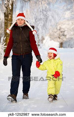Three years old girl with mother in snowy parkway View Large Photo Image Stock Photo - Three years old girl with mother in snowy parkway. Fotosearch