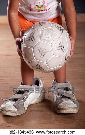 Three years old little girl playing with a soccer ball with man's sneakers View Large Photo Image Stock Image - Three years old little girl playing with a soccer ball with man's sneakers. Fotosearch