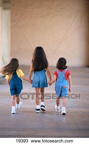 Stock Image - Three young girls walking away. Fotosearch