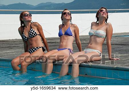 three young woman at swimming pool, summertime View Large Photo Image Picture - three young woman at swimming pool, summertime. Fotosearch
