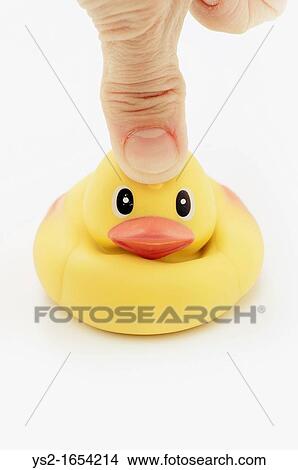 Picture - Thumb pressing on head of rubber duck. Fotosearch