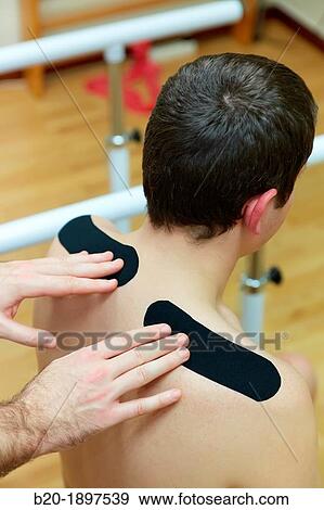 Thumbnail kinesiotaping strips on trapezes to treat contractures Gym, Physiotherapy medical center, Donostia, San Sebastian, Gipuzkoa, Basque Country, Spain View Large Photo Image Stock Photo - Thumbnail kinesiotaping strips on trapezes to treat contractures Gym, Physiotherapy medical center, Donostia, San Sebastian, Gipuzkoa, Basque Country, Spain. Fotosearch