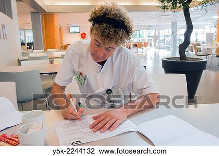 Tilburg, Netherlands. Female Physio therapist working on her planning for the treatment of hospital patients, while being on her coffee brake. View Large Photo Image Stock Image - Tilburg, Netherlands. Female Physio therapist working on her planning for the treatment of hospital patients, while being on her coffee brake.. Fotosearch