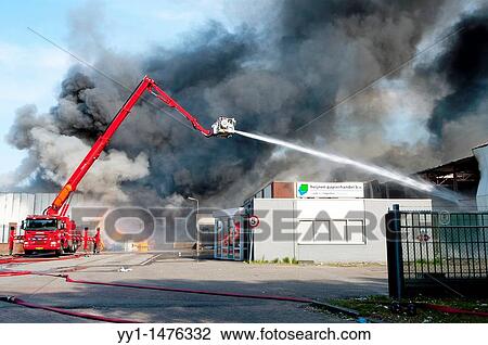 Stock Image - Tilburg, Netherlands. Large fire at a recycling-company for used paper in may 2011. Smoke from the fire was visible in a large area and over 150 firefighters battled the blaze.. Fotosearch