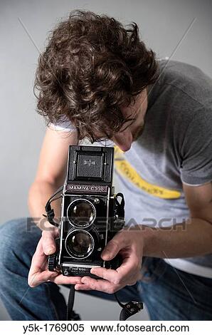 Tilburg, Netherlands. Man with a vintage medium format twin lens reflex camera. Studio-portrait against grey background. View Large Photo Image Stock Photography - Tilburg, Netherlands. Man with a vintage medium format twin lens reflex camera. Studio-portrait against grey background.. Fotosearch