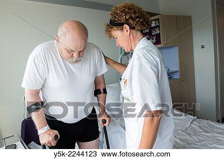 Tilburg, Netherlands. Physio therapist instructing a male post operative patient on how to walk again, after reviving a new hip in surgery. View Large Photo Image Stock Image - Tilburg, Netherlands. Physio therapist instructing a male post operative patient on how to walk again, after reviving a new hip in surgery.. Fotosearch