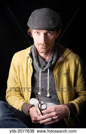Tilburg, Netherlands. Portrait of a young man with cap and glasses. View Large Photo Image Stock Photo - Tilburg, Netherlands. Portrait of a young man with cap and glasses.. Fotosearch