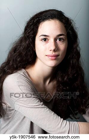 Tilburg, Netherlands Portrait of a young brunette against a grey background, sitting on a stool View Large Photo Image Stock Photograph - Tilburg, Netherlands Portrait of a young brunette against a grey background, sitting on a stool. Fotosearch