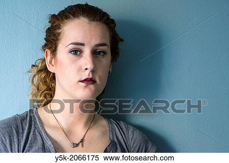 Stock Photography - Tilburg, Netherlands. Portrait of a young woman, leaning against a wall.. Fotosearch